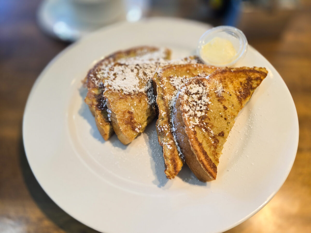 Miss Daisy's French Toast topped with Powdered Sugar and a side of butter