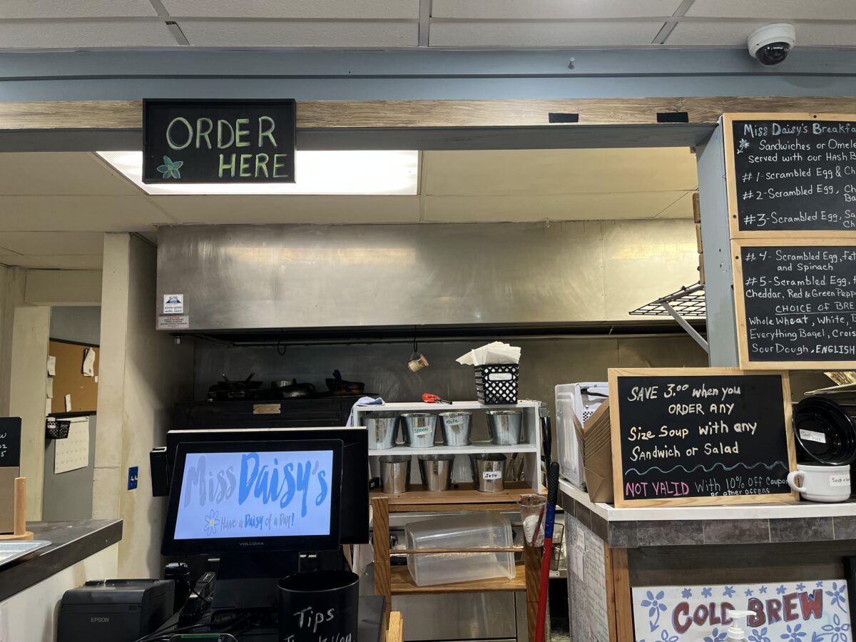 Close-up of the POS order screen and small chalkboard sign advertising a special deal on soup and sandwich.